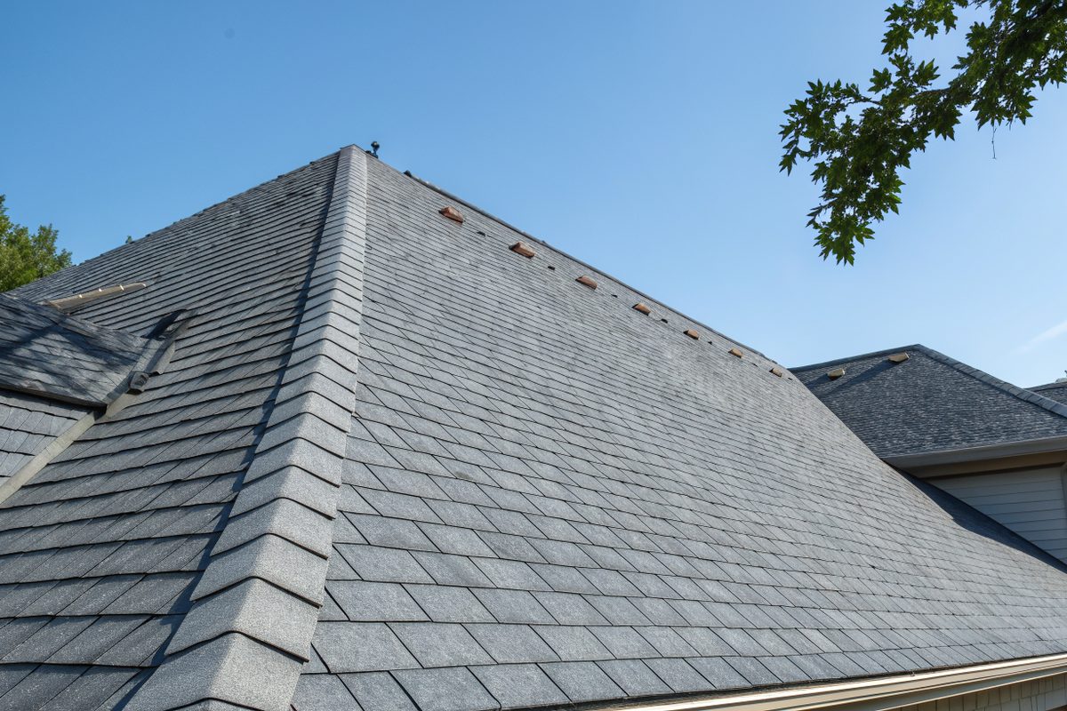 A gray shingle roof with a ridge vent along the peak